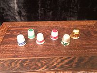 All six thimbles arranged in a row on wood surface
