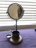 Front view of silver-plated shaving stand showing mirror, holder and dish