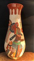 Front view of tall pottery vase showing warrior figure and drip-style rim
