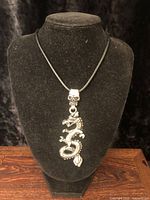 Full view of dragon pendant necklace on display bust