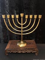 Front view of full menorah showing nine cups and arched branches