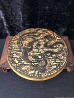 Front view of round carved printing block showing dragon and garuda design