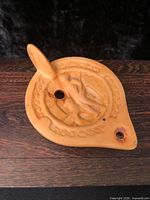 Top view showing relief decoration, fill hole, wick spout