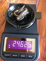 Earrings on digital scale showing 24.625 g