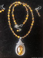 Full view of tiger eye bead necklace with pendant and both earrings