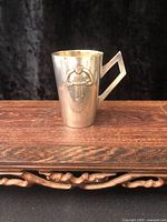 Full view of silverplate cup on wooden surface