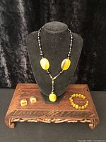 Full lot showing necklace on bust, bracelet, cufflinks
