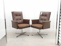 Both brown faux leather swivel armchairs front view