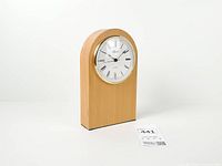 Front angled view of Hermle wooden mantel clock showing arched case and dial