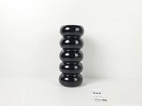 Full front view of glossy black five-tier ceramic vase