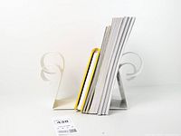 Pair of white metal scroll bookends holding books, front view