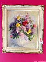 Full view of framed floral oil painting against pink wall