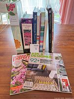 Front view of all books standing plus two magazines laid flat