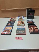 Group shot of all eight DVD titles on tabletop with lot number