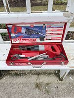 Saw inside open red Milwaukee case with blades