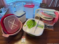 All items grouped on table showing salad spinner, pitchers, colander, storage container and disposables