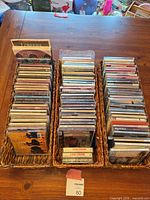 Three baskets filled with rows of music CDs in jewel cases