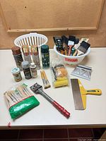 Overall view of brushes, rollers, aerosols and tools on table