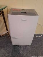 Front view of NOMA dehumidifier showing brand logo and bucket line