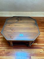 Top view of octagonal wood coffee table showing finish and wear