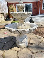 Full view of assembled two-tier cast stone fountain outdoors