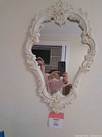 Front view of ornate cream and gold wall mirror