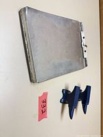 Overall view: metal clipboard and two mini blue anvils