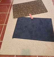Beige rug with brown and blue rugs placed on top