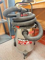 Front view of Shop-Vac showing hose, label and wheels