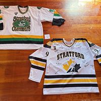 Both Stratford signed jerseys laid flat, showing front designs and colours