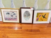 All three framed pieces side by side on floor showing subjects and frames