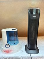 Vicks V750 humidifier wrapped in protective plastic beside NOMA tower heater