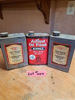Front view of three vintage 1 L metal wood oil/stain cans: Minwax Antique Oil Finish flanked by two CIL Penetrating Oil-Stain