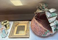 All four items: wicker basket, ornate gold frame, angel figurine, decorative tin