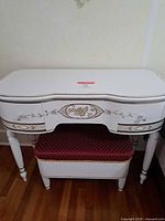 Front view of white French Provincial vanity with matching bench under tabletop