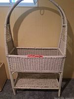 Front view showing full wicker plant stand with arch, planter basket, lower shelf
