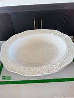 top view of oval white platter with embossed scroll border