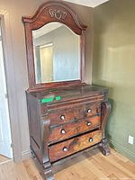 Front view showing dresser, mirror, scroll feet, drawer configuration