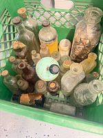 Top view of crate containing assorted antique and vintage glass bottles and jars