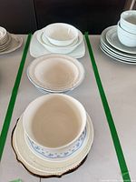 Multiple stacks showing bowls and plates with blue floral and green rim designs
