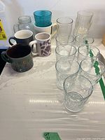 Countertop view showing full assortment of glass tumblers, mugs, Coors jar