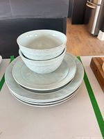 Stack of two bowls atop salad plate and dinner plates showing glaze color and rim detail