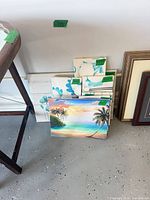 Stacked canvas prints showing tropical beach scene front and multiple teal floral prints behind