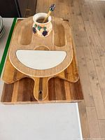 All items stacked: three boards, ceramic pot, spoon