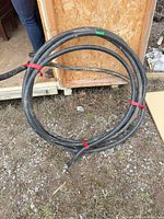 Coiled flexible metal conduit on ground showing overall length and jacket