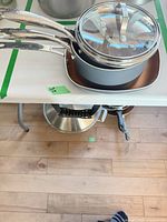 Cookware stacked showing grey exterior, lids, stainless handles