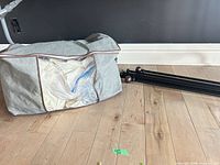Storage bag, folded curtains inside plastic, four black rods with finials