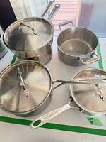 Top view of both pans and lids showing overall condition and brand handles