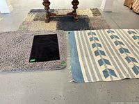 Three rugs: light gray shag with small dark mat on top, kilim rug adjacent, part of large mottled shag visible