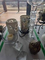 Overall lot showing various candle holders, crystal prisms and carved sphere